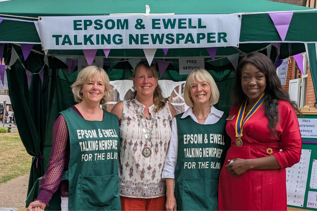 Four volunteers standing under a gazebo