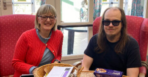 A talking newspaper volunteer sat next to a blind member of the Banstead Club